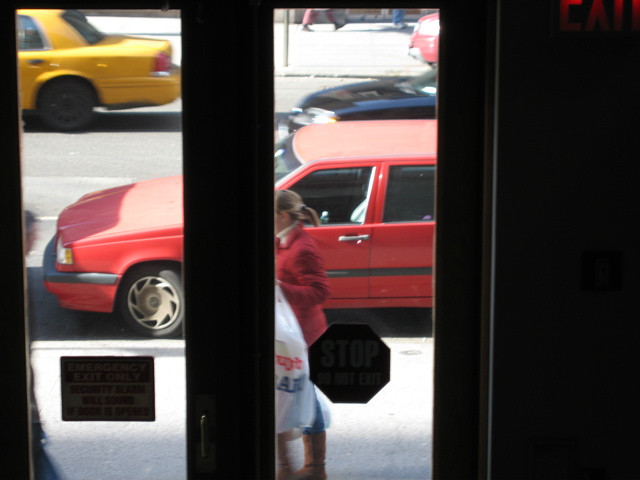A women, bundled up and a man just entering the scene; a cab, a black car; pink pants in the far background