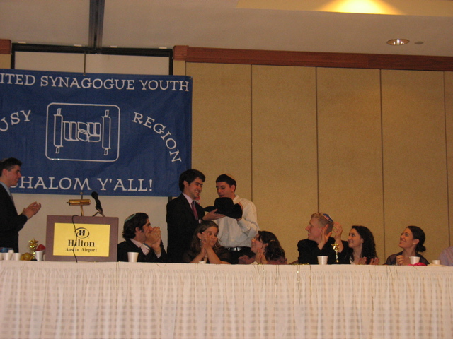 Daniel presents a (sweet!) cowboy hat to Moshe