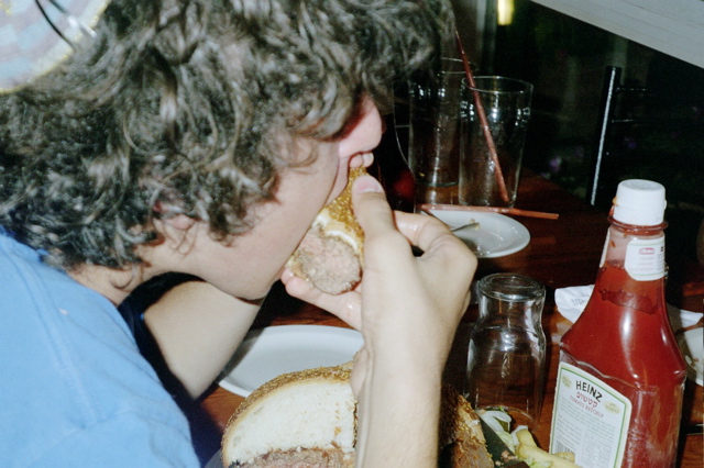 Nathan eating a quarter of his Sumoburger