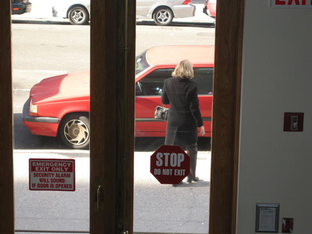 A blonde woman stops at the car. Is it her car?