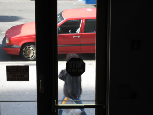 A woman with a shoppoing bag; the shadow of a vehicle