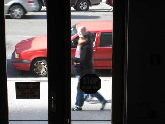 Two girls; An automobile goes by; an SUV has taken the open background parking spot