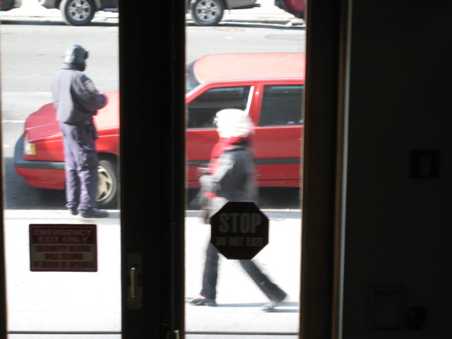 A woman rushes past the policeman