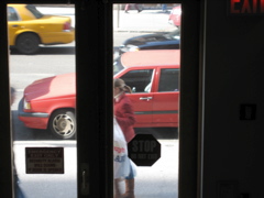 A women, bundled up and a man just entering the scene; a cab, a black car; pink pants in the far background