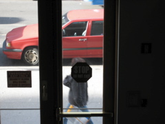 A woman with a shoppoing bag; the shadow of a vehicle