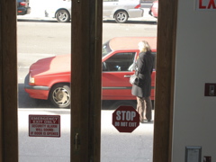 The woman looks at the car as if she is preparing to enter.