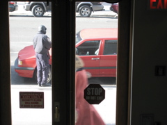 A woman in red walks past the policeman at the car