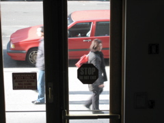 A man passes a woman with a very bright red purse